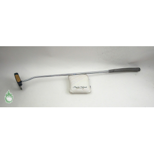 Steel golf putter with black head and gray grip resting on an Angeles National Golf Club headcover.
